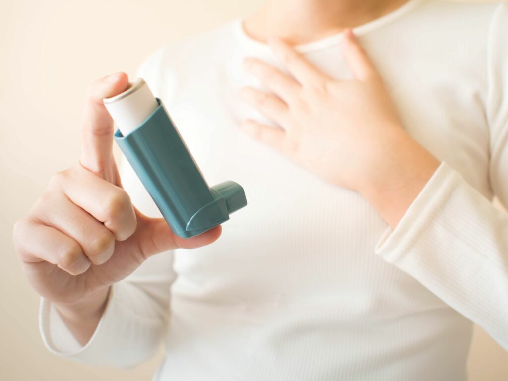 Frau hält Inhalationsspray in der Hand Inhalationsspray gegen Allergie